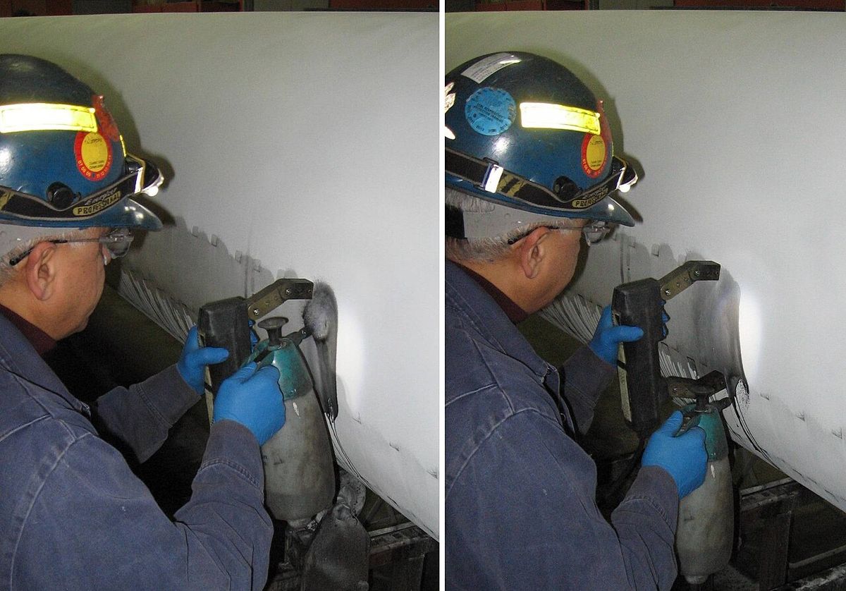 Technician performing wet magnetic particle testing on a pipeline weld